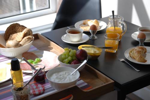 海牙欧泊里齐特斯特拉特住宿加早餐旅馆的一张桌子,上面放着早餐食品托盘
