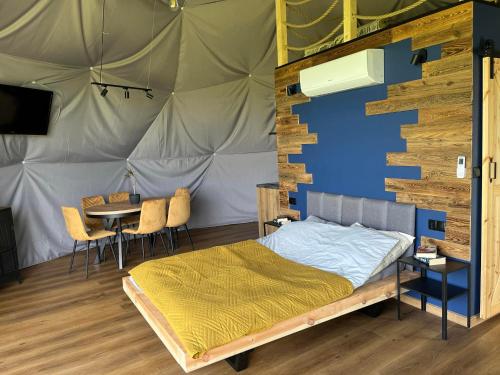 Karwieńskie Błoto DrugieGlamping HEN W TRAWIE的一间卧室,配有带一张床和一张桌子的帐篷