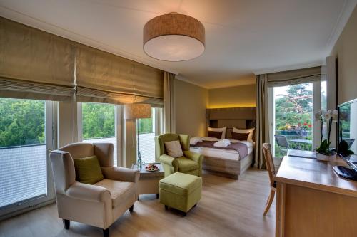 黑灵斯多夫Upstalsboom Heringsdorf的客厅配有床、沙发和椅子