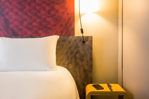 波尔多波尔多市中心圣让车站宜必思酒店的一间卧室配有一张床和一张带台灯的桌子