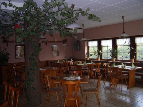 艾森纳赫An der Linde的一间设有桌椅的餐厅,还有一棵树