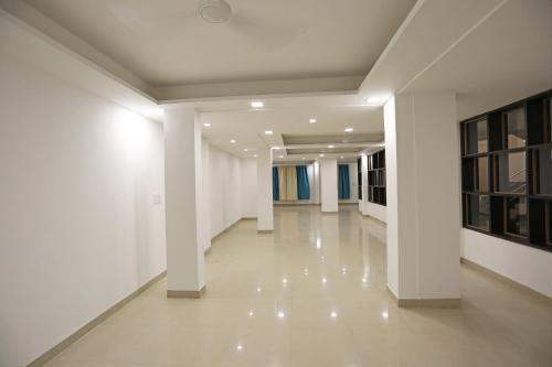 博帕尔Super Hotel O Danish Nagar Hosangabad Rd的白色墙壁和白色地板的建筑走廊