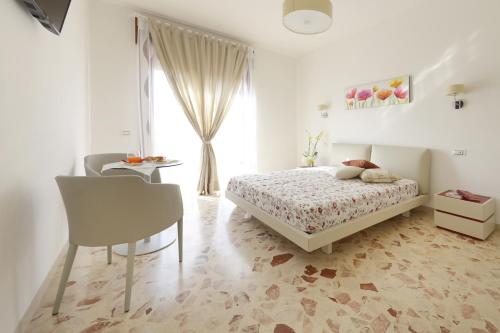 萨莱诺玫瑰生活住宿加早餐旅馆的卧室配有1张床、1张桌子和1把椅子