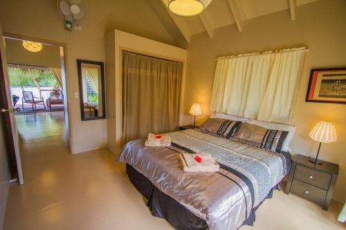拉罗汤加Cook Islands Holiday Villas - Muri Lagoon Beachfront的一间卧室配有一张床,上面有两条毛巾