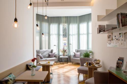 巴塞罗那卡萨马蒂尔达酒店的客厅设有桌椅和窗户。