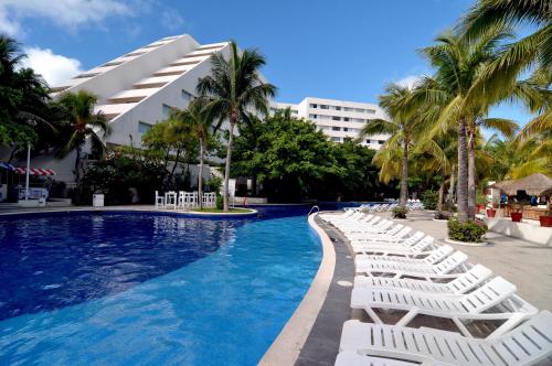 坎昆Grand Oasis Palm - All inclusive的游泳池旁的一排白色躺椅