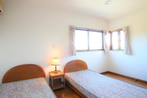 南房总市南房总市农场旅馆山林小屋的一间卧室设有两张床和窗户。