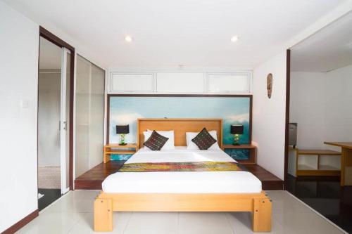 坎古水上巴厘别墅酒店的一间卧室配有一张大床和木制床头板
