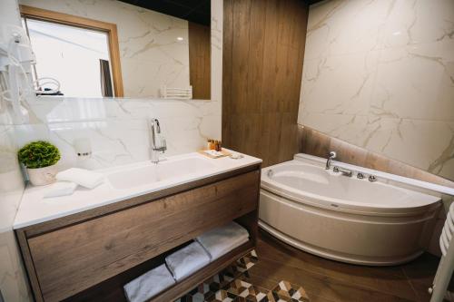 普列文Хотел Панорама的带浴缸、水槽、浴缸和卫生间的浴室。