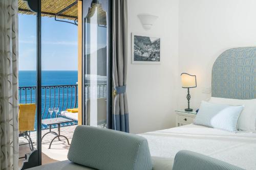 波西塔诺Albergo Miramare Positano的一间卧室设有一张床和一个海景阳台