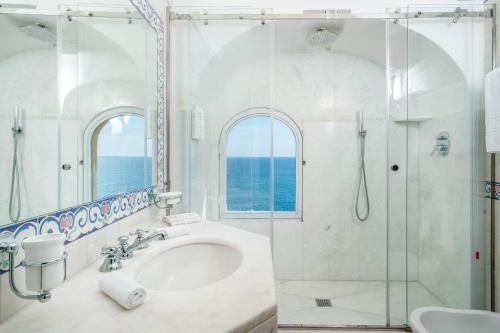 波西塔诺Albergo Miramare Positano的带淋浴和盥洗盆的白色浴室
