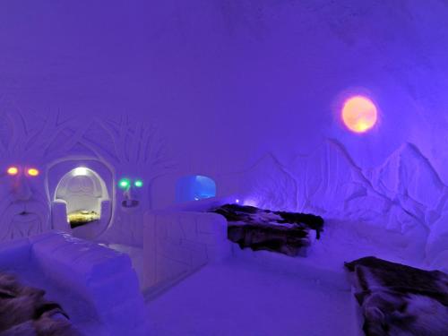 哈山Hunderfossen Snow Hotel的一间冰屋,配有紫色灯和一张床