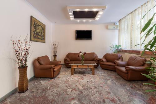 布尔加斯Family Hotel Central的客厅配有真皮沙发和电视
