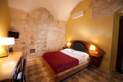 莱切B&B Residenza Pizziniaco的一间卧室配有一张石墙床