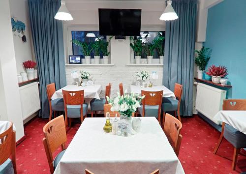 波兹南黄金酒店的用餐室配有桌椅和平面电视。
