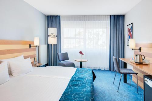 美因河畔法兰克福法兰克福机场城际酒店的配有一张床和一张书桌的酒店客房