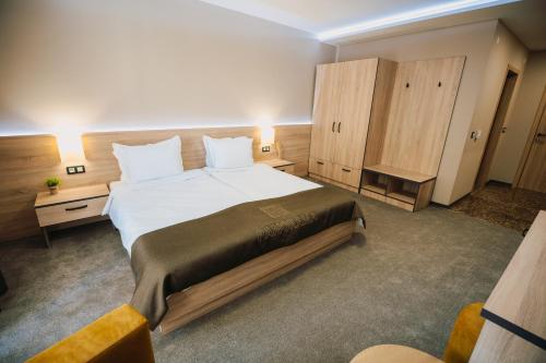 普列文Хотел Панорама的一间卧室配有一张大床和两个橱柜