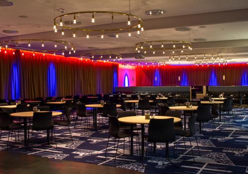 耶利瓦勒Grand Hotel Lapland的一间配备有桌椅和红色及蓝色窗帘的用餐室