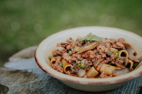 CampodimeleOstello Ossigeno的桌上一碗面食,包括肉类和蔬菜