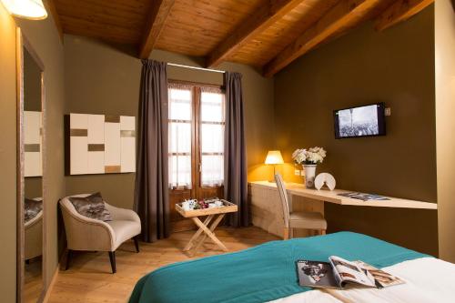 博尔戈塞西亚La Burla的一间卧室配有一张床、一张书桌和一个窗户。