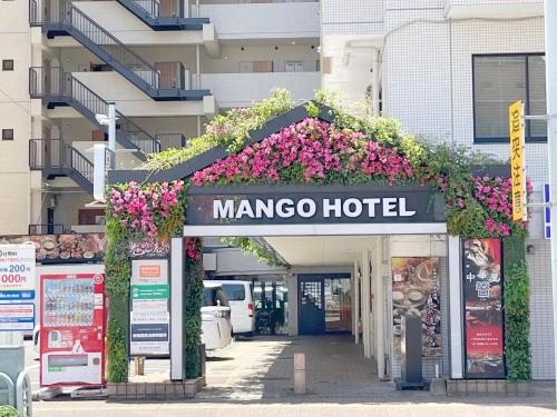 宫崎Miyazaki Mango Hotel的鲜花盛开的马可酒店的入口