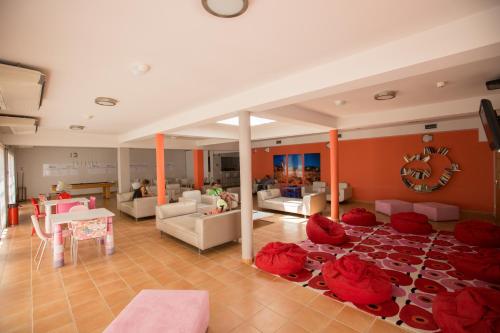 波尔蒂芒HI Portimão - Pousada de Juventude的一间大客厅,地板上配有红色枕头