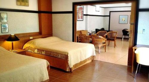 拉差汶里Numsin Hotel的一间酒店客房,设有两张床和一间餐厅