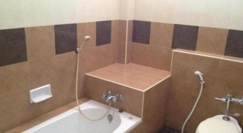 拉差汶里Numsin Hotel的带浴缸和卫生间的浴室。
