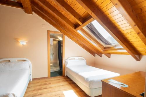 拉林Hotel Alda Lalín的一间卧室设有两张床和天窗