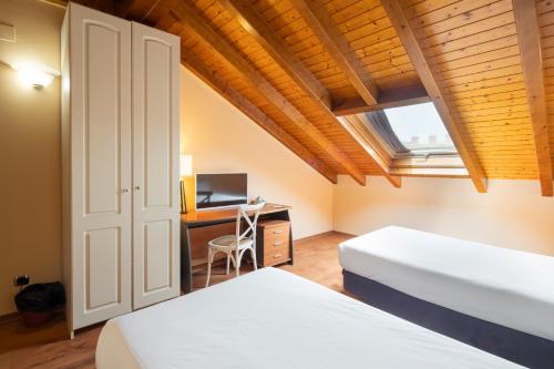 拉林Hotel Alda Lalín的配有书桌和窗户的客房内的两张床