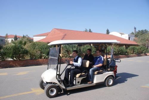 巴库新月海滩酒店的三个男人在街上骑高尔夫球车