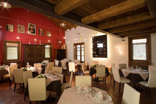 博尔戈塞西亚La Burla的一间设有白色桌椅和红色墙壁的餐厅