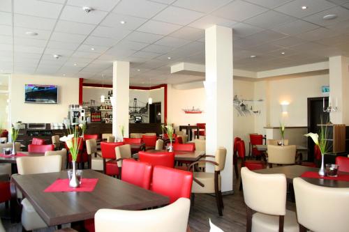 威廉港家园酒店的用餐室配有桌子和红色椅子