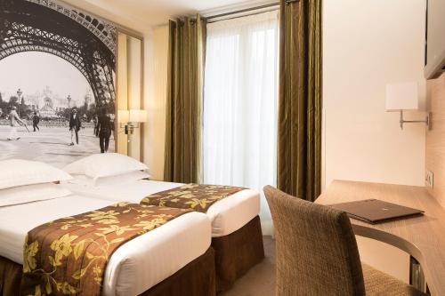 巴黎杜尔那马莱酒店的酒店客房配有两张床和一张带笔记本电脑的书桌
