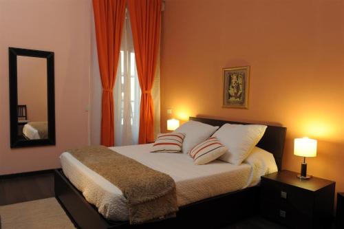 罗马亚历山大B&B酒店的一间卧室配有一张带两个枕头和镜子的床