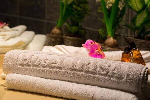 布加勒斯特艾里萨酒店的一张桌子上的毛巾,上面有粉红色的花