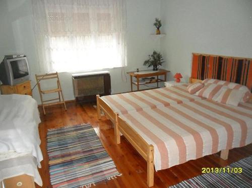 MátraderecskeMuskátlis vendégház的一间卧室配有一张大床和电视