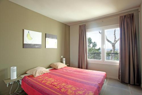 米哈斯科斯塔米拉弗洛雷斯花园公寓的一间卧室设有一张大床和一个窗户。