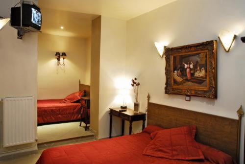 巴黎阿维农酒店的一间卧室设有两张床,墙上配有电视。