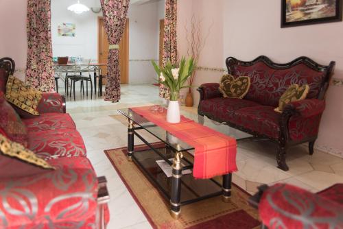 达卡巴比伦酒店及服务公寓的客厅配有两张红色的沙发和一张桌子
