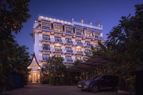 暹粒Two Seasons Siem Reap Hotel的前面有停车位的建筑