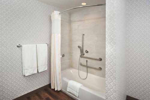 伯班克Hilton Garden Inn Burbank Los Angeles的浴室配有浴缸、淋浴和毛巾。