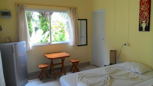 蔻立阿斯德花园考拉度假屋的一间卧室配有一张床、一张桌子和一个窗户。