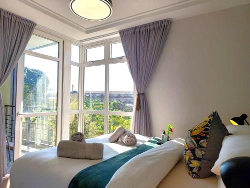 South EndBrizzys Balcony Luxe Retreat Great Location!的一间卧室设有两张床和大窗户