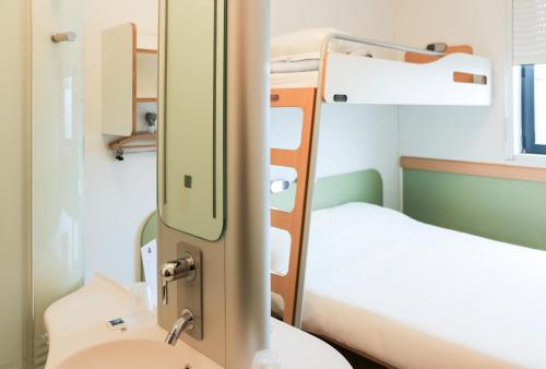 卡斯泰尔诺达里ibis budget Castelnaudary - A61的一间医院间,配有两张床和盥洗盆