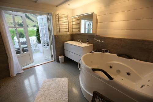 奥勒松阿尔内斯嘉德公寓的带浴缸、水槽和镜子的浴室