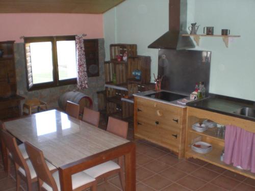 CastilsabásEl Pajar的一间带桌子的厨房和一间餐厅