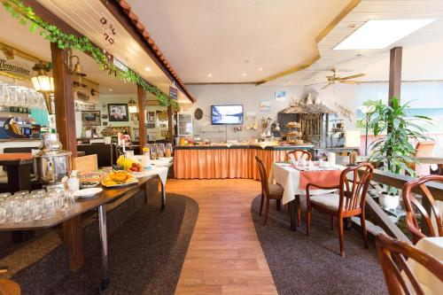青斯特Hotel Garni Am Deich的一间带桌椅和柜台的餐厅