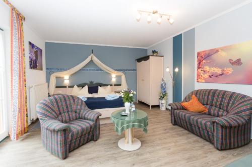 青斯特Hotel Garni Am Deich的客厅配有两把椅子和一张床