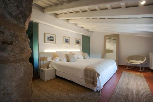 阿维约内普温Mas Falgarona Hotel Boutique & SPA的卧室配有白色的床和桌子